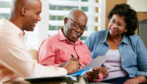 Financial Advisor Talking To Senior Couple At Home