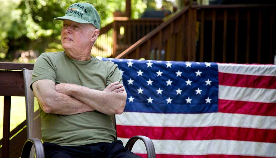 Vietnam Veteran sitting in backyard, American Flag in background.