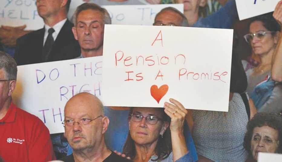 Older adults protesting for pensions, a woman holding up a sign "A Pension is a Promise". 