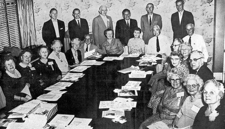 A group of people gathered around a table for an AARP meeting.