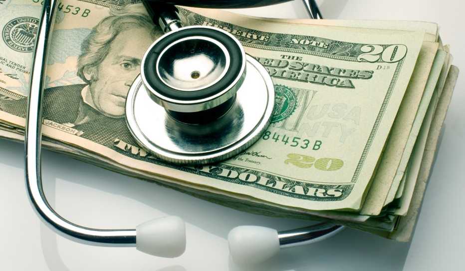 A stethoscope sitting on top of a pile of money A stethoscope sitting on top of a pile of money