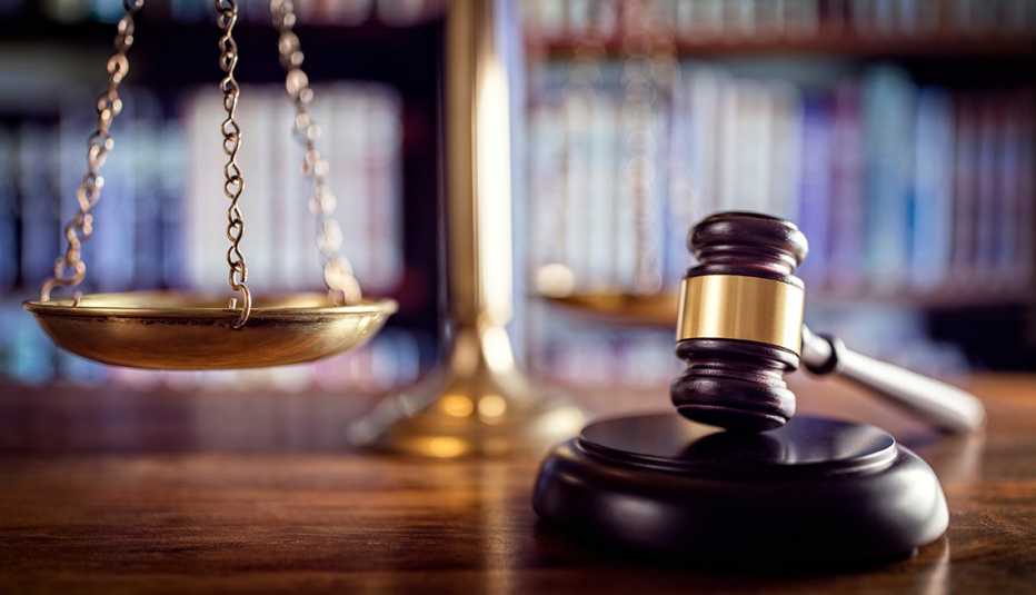 A brown gavel with the scales of justice sitting on a table