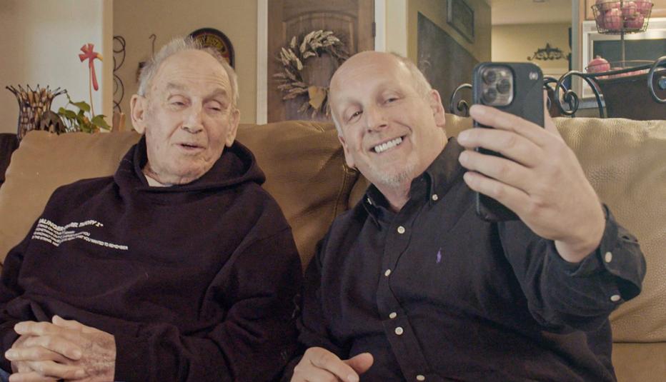 Ed and Dan Salinger sitting on a couch as they film a video on a smartphone Ed and Dan Salinger sitting on a couch as they film a video on a smartphone