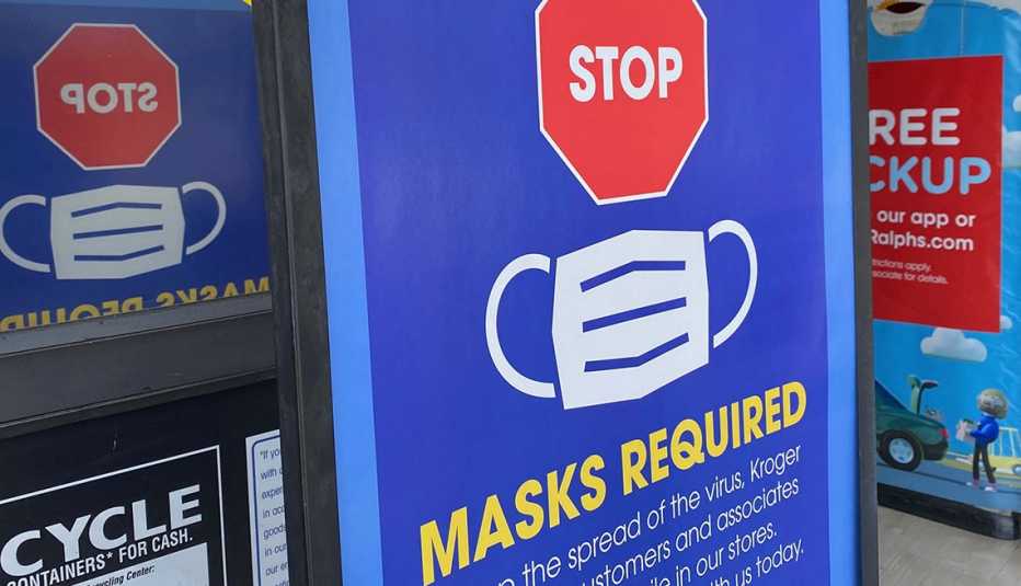 a sign is posted at the entrance of a store telling people not to enter without a mask