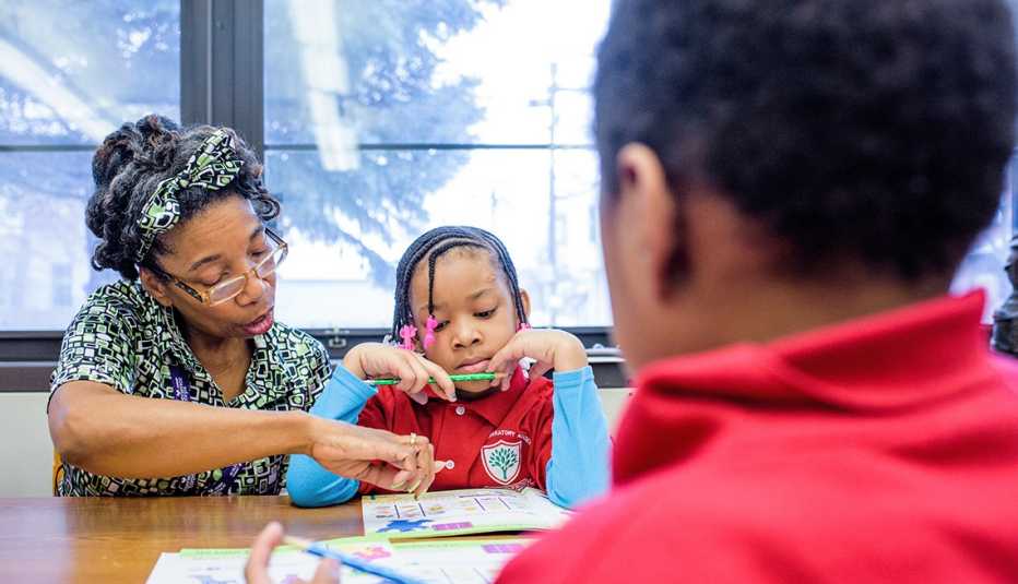 A woman is teaching a child in a class A woman is teaching a child in a class