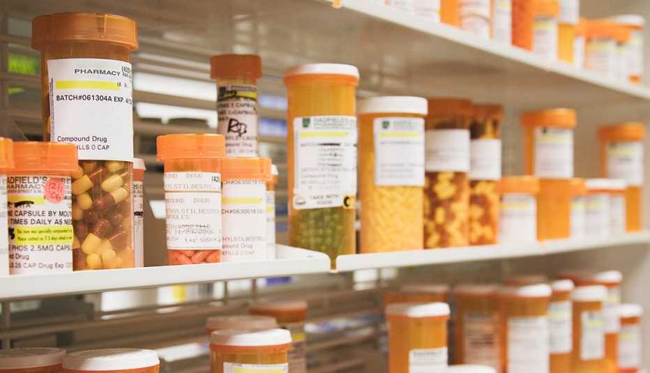 rows of prescription pill bottles on a pharmacy shelf rows of prescription pill bottles on a pharmacy shelf