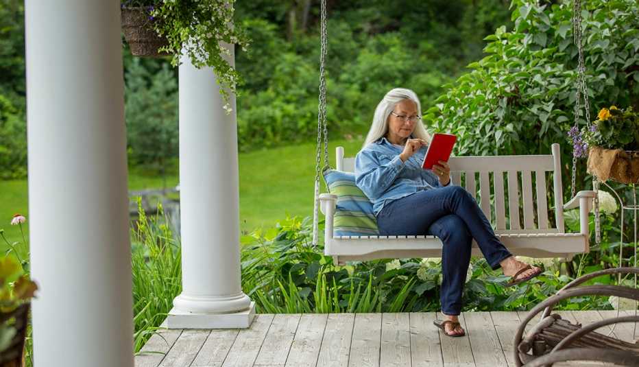 Woman using digital tablet on porch swing