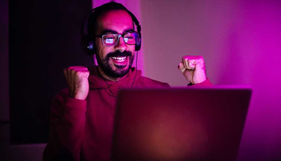 Adult man playing a video game on laptop happy man playing a video game and winning