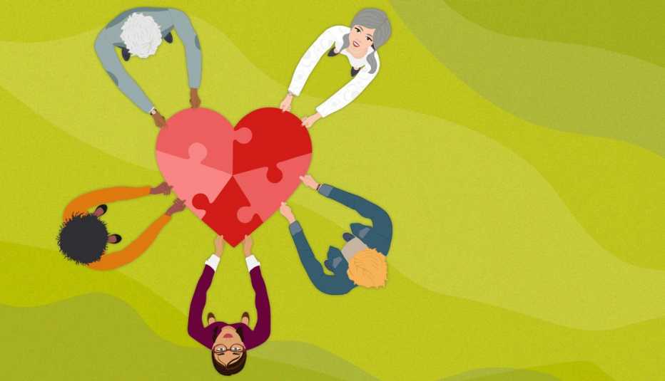 circle of people holds a heart shaped trampoline and some of them look up