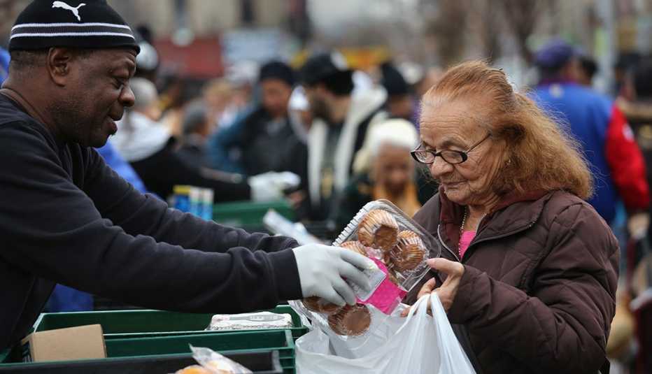 An older woman buying food from a market