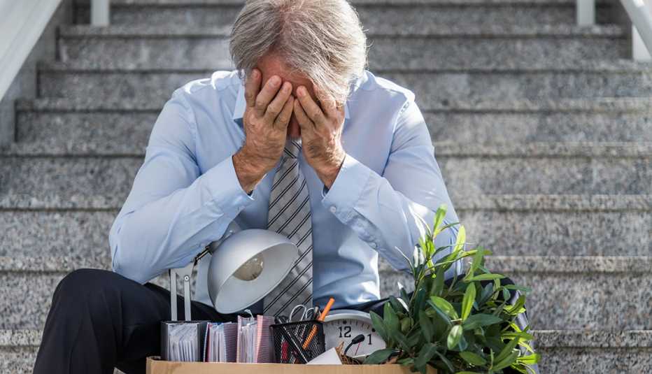Older man sitting on the start after being fired from his job.