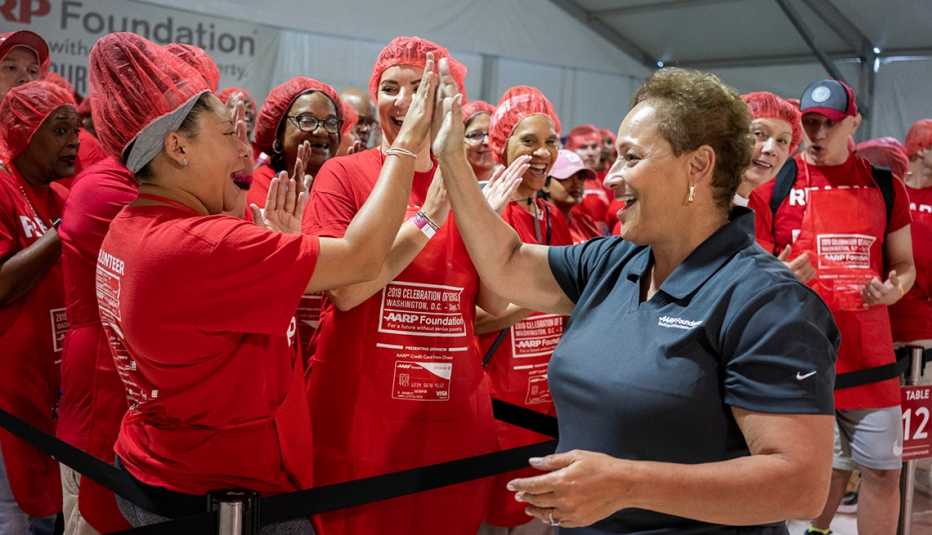 AARP CEO Jo Ann Jenkins high fives a volunteer at AARP Foundation's 2019 Celebration of Service