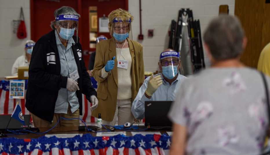 People waiting to vote in an election all wearing masks