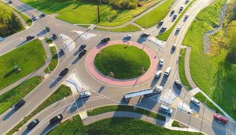aerial view of a busy city roundabout intersection at sunrise rush hour