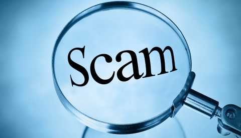 a magnifying glass over the word scam on a blue background a magnifying glass over the word scam on a blue background