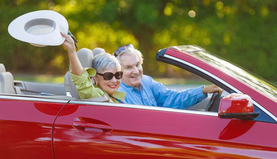 couple driving red convertible