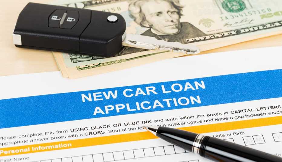 Car loan application with car key and dollar banknote Car loan application with car key and dollar banknote