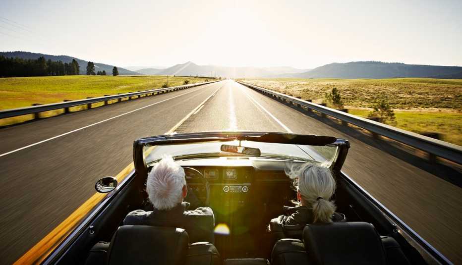 a couple driving in a convertible car