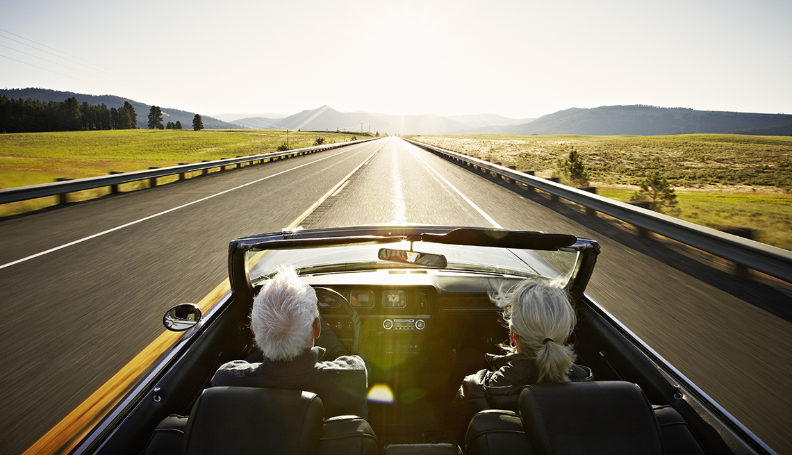 a couple driving in a convertible car