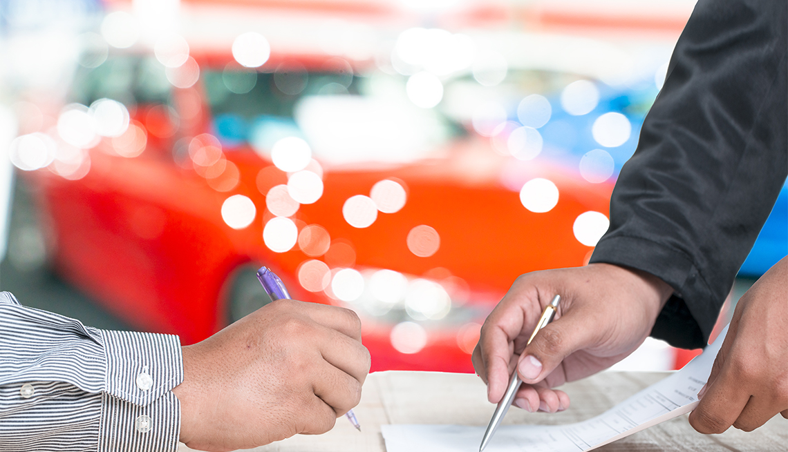 Man signing car insurance document or lease paper.
