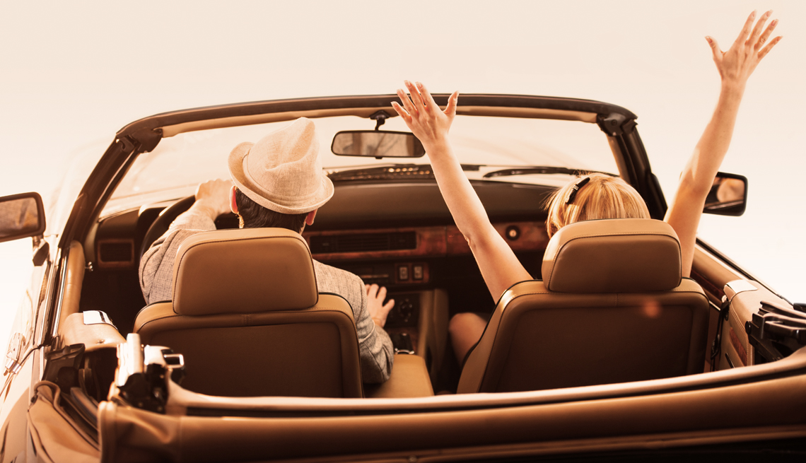 couple driving in an retro convertible car