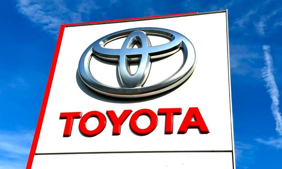 a toyota sign a toyota logo on a white sign against a blue sky