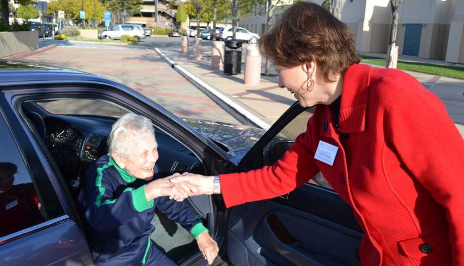 A passenger gets a helping hand from Nancy Budd, the executive director of iTNMontereyCounty.