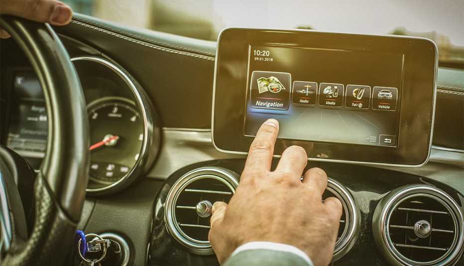 Close up of driver hand using touch screen in car