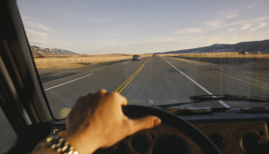 mans hand on steering wheel