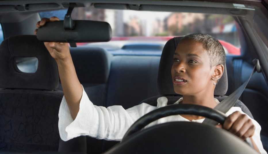 woman adjusting rear view mirror