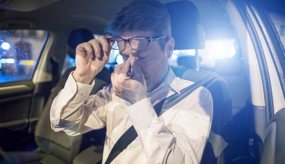 Tired male driver inside car at night