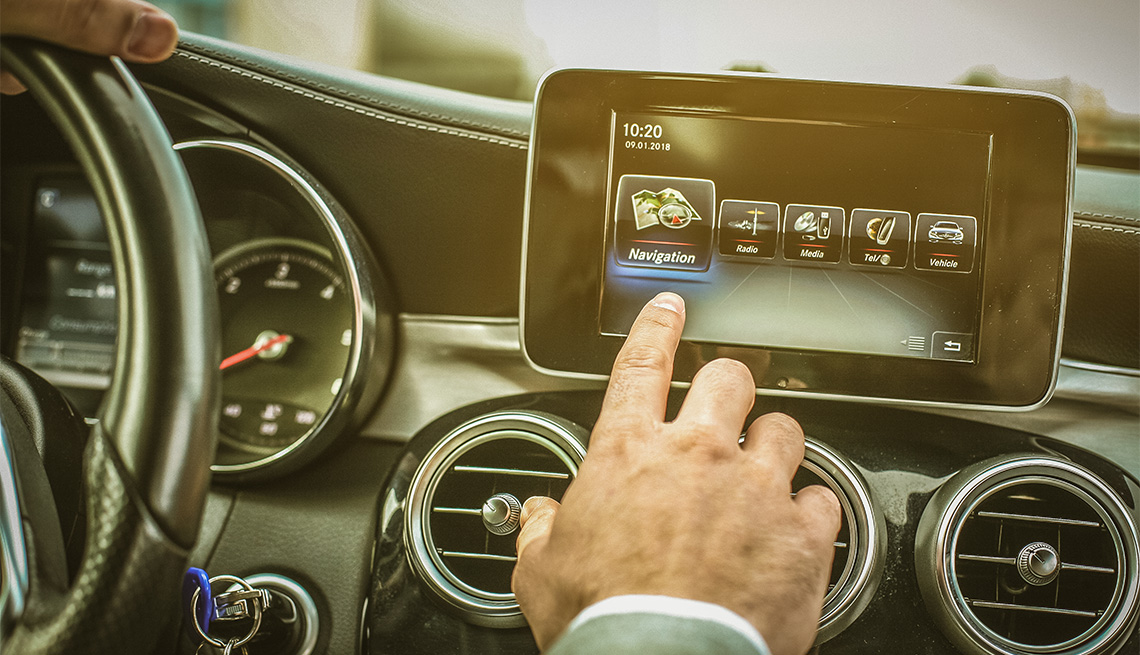 Close up of driver hand using touch screen in car