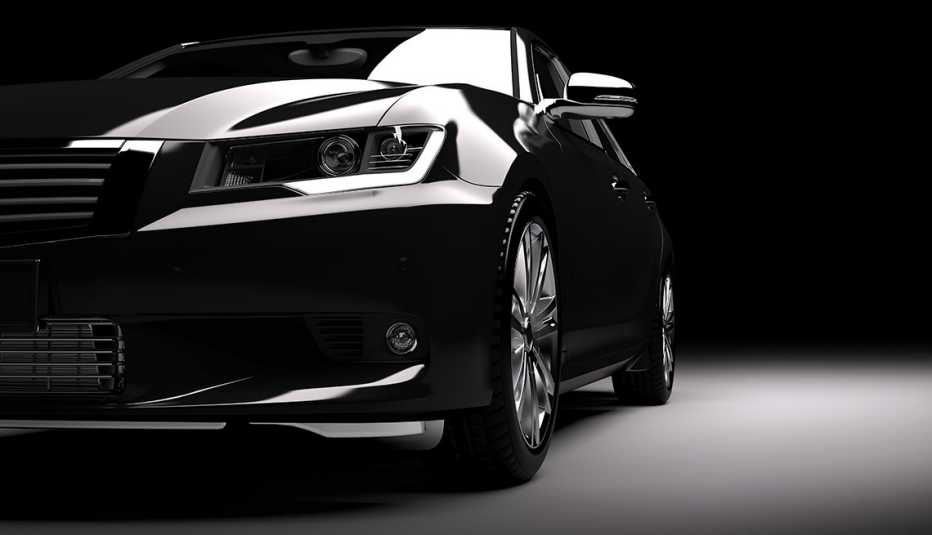 Modern new black metallic sedan car in spotlight