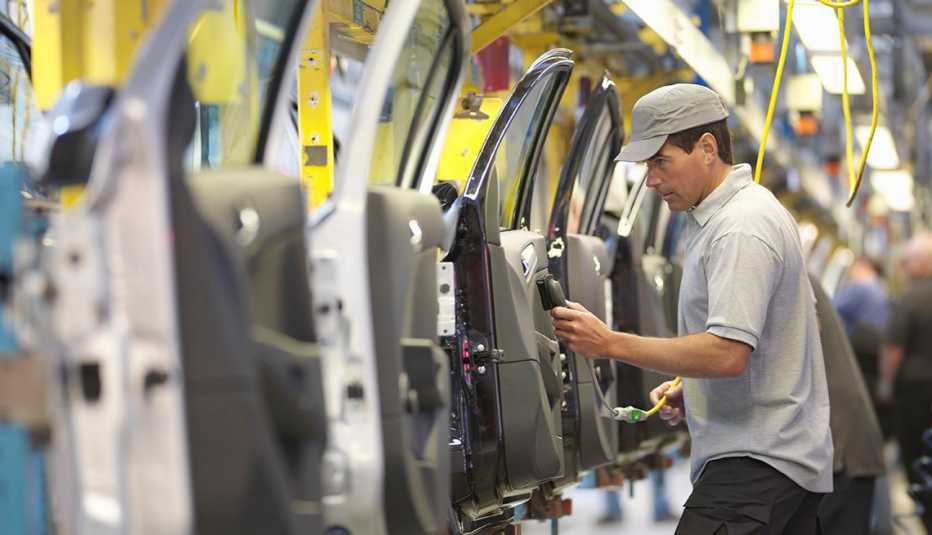 A man in a warehouse that manufacturers cars