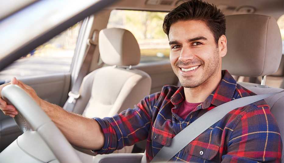 Young man in car driving seat looking to camera