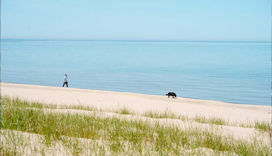 man walking dog on beach at jean klock park