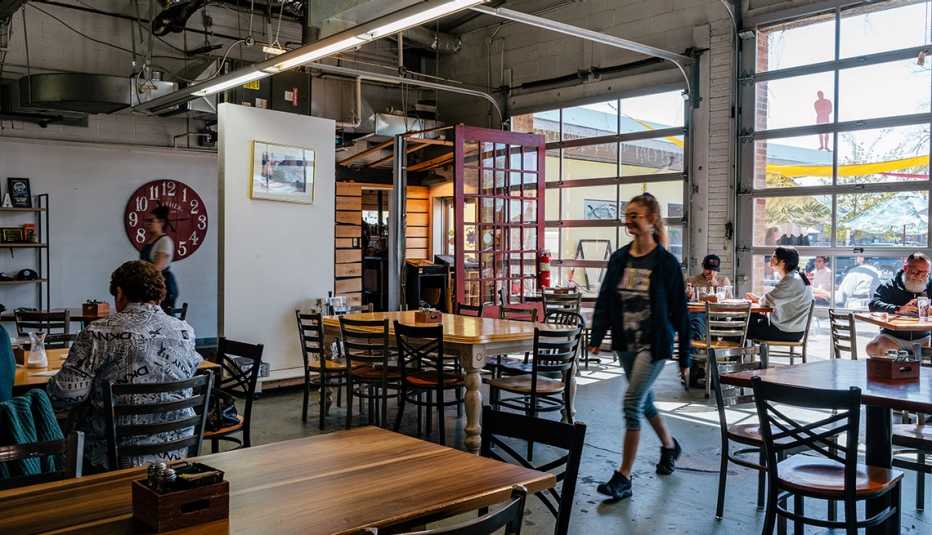 woman walking and people sitting at tables in the mason jar café