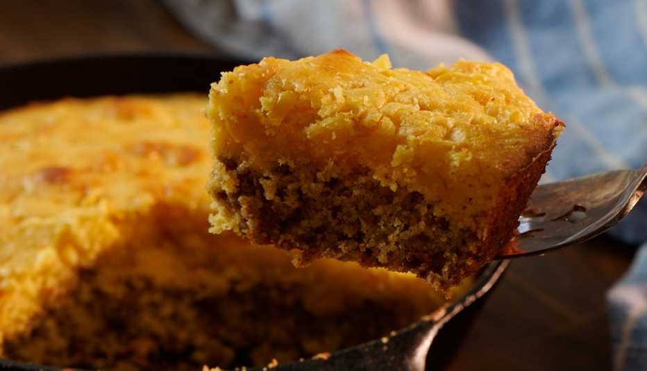 spoon pulling piece of mexican cornbread out of pan