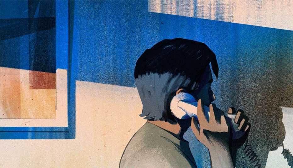 teenage boy holding a telephone receiver to his ear with his palm on the mouthpiece