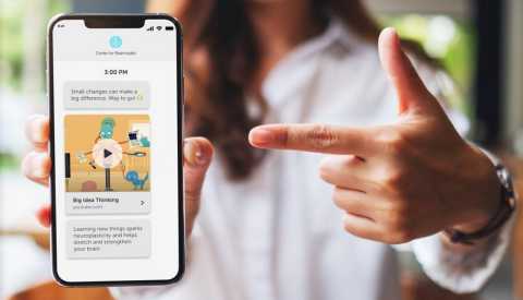 A woman's hand pointing at the screen of a cell phone