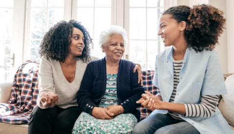 Three women sitting on a couch and talking to each other
