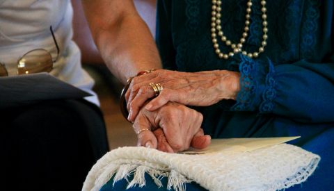 A close-up view of the hands of two people holding one another
