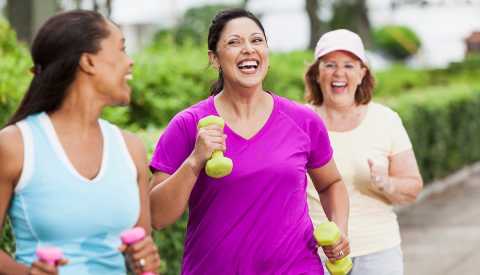 Three women power walking in a park