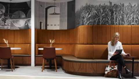 A woman working on a tablet in an empty cafe