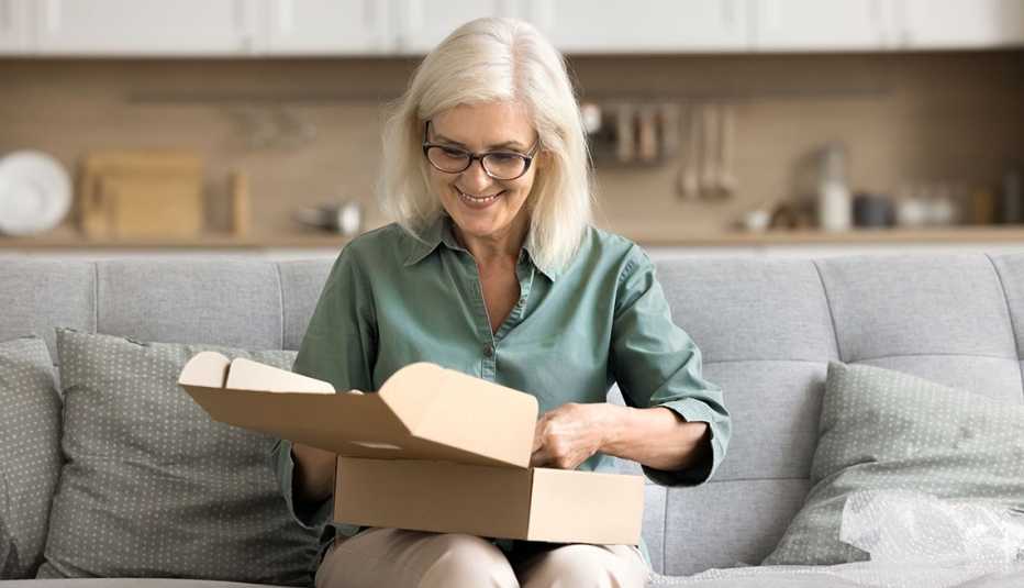 A woman happily unpacking a delivery box at home