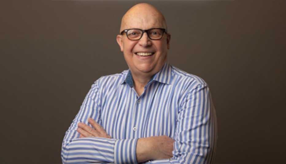 A portrait of Steven with arms crossed against a brown background