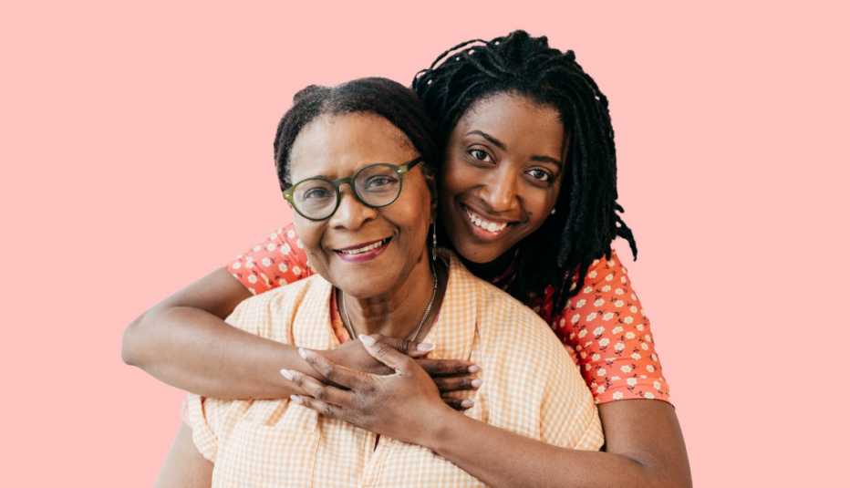 Two smiling women with one hugging the other from behind