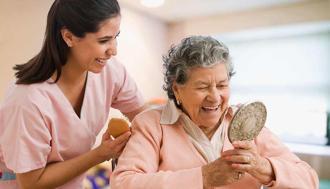 nurse helping senior woman with hair