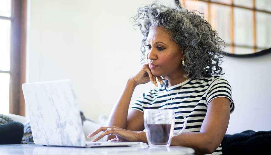 Woman at home typing on her computer