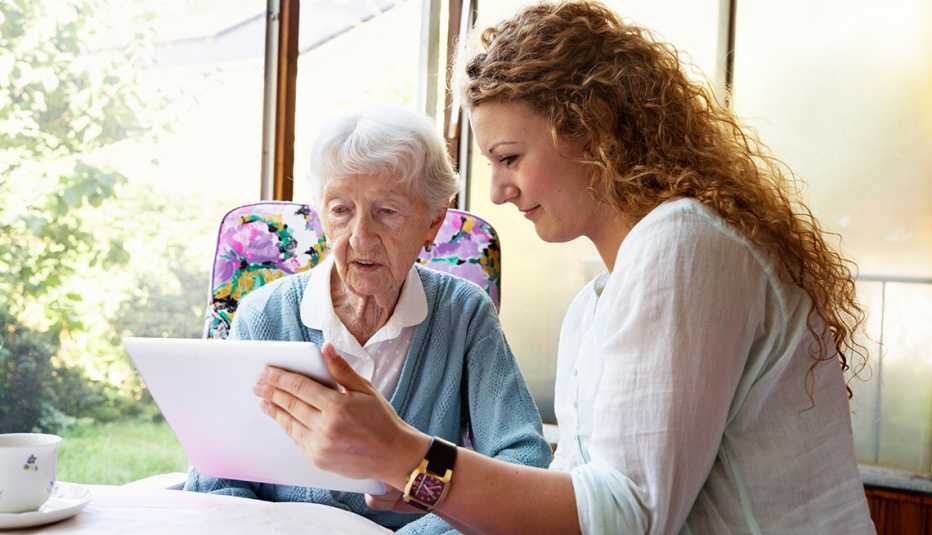 A woman showing a tablet to her grandmother